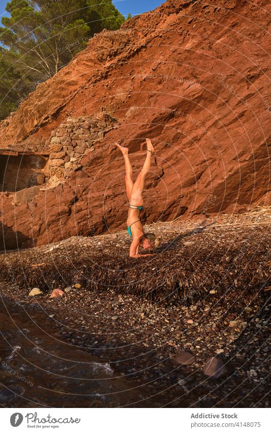 Frau beim Handstand Yoga Position am Strand vertikal winken MEER Bewegung natürlich Wald Pose Invers Fitness Sport Stärke Gesundheit Athlet Übung stark Training