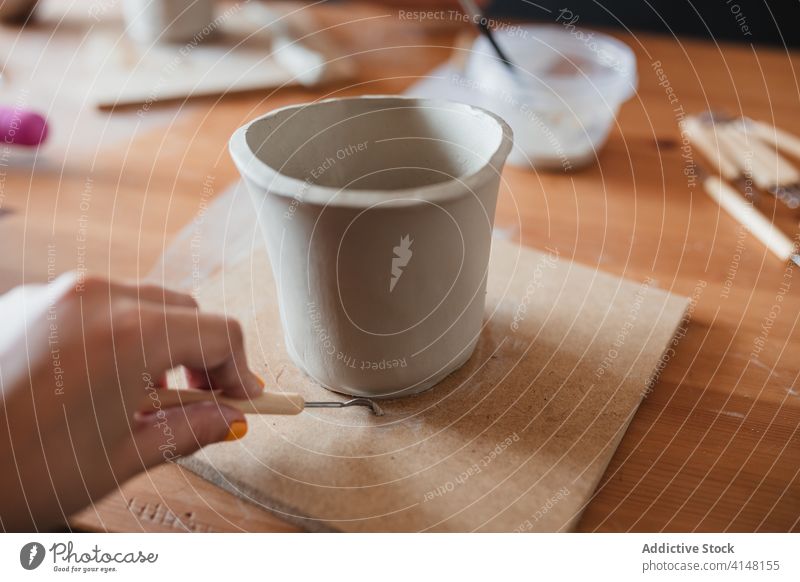 Handwerkerin bei der Herstellung einer Keramiktasse in einer Werkstatt kreieren Kunstgewerbler Ton Werkzeug handgefertigt Fähigkeit Frau professionell Becher
