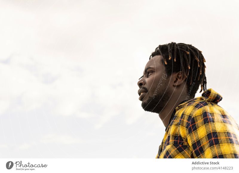 Profil eines Schwarzen mit dem Himmel im Hintergrund Afrikanisch Person Porträt jung Amerikaner schwarz Mann männlich gutaussehend Typ Blick attraktiv Afro-Look