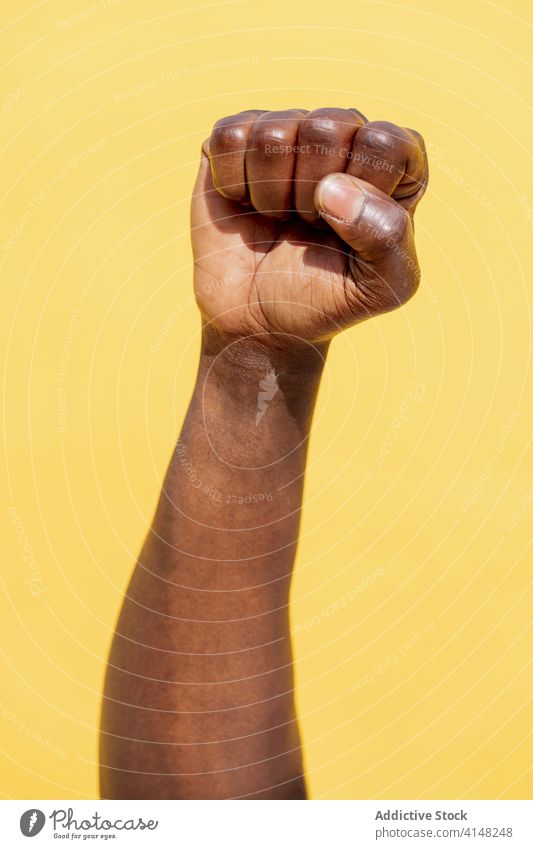 Vertikales Foto einer erhobenen Faust eines schwarzen Mannes protestieren Person rechts kämpfen Kraft Hand Freiheit Stärke menschlich Revolution stark Arme