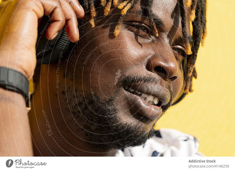 Nahaufnahme eines schwarzen Mannes, der Musik hört und genießt Person Kopfhörer Afrikanisch Amerikaner Porträt Lebensstile jung Afro-Look Lächeln Typ hören