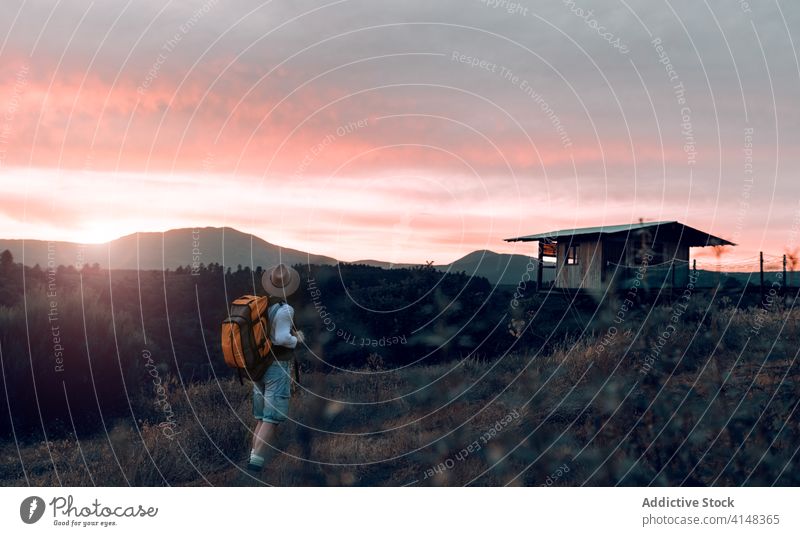 Anonymer Mann in ländlicher Umgebung bei Sonnenuntergang Reisender Berge u. Gebirge genießen Feld Rucksack Tourist Abend männlich malerisch Fernweh Himmel