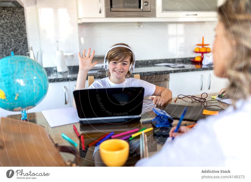 Junge grüßt während eines Videoanrufs auf dem Laptop Hallo Kommunizieren Gruß lernen Kindheit Mutter benutzend Gerät Apparatur zuschauend Netbook Internet