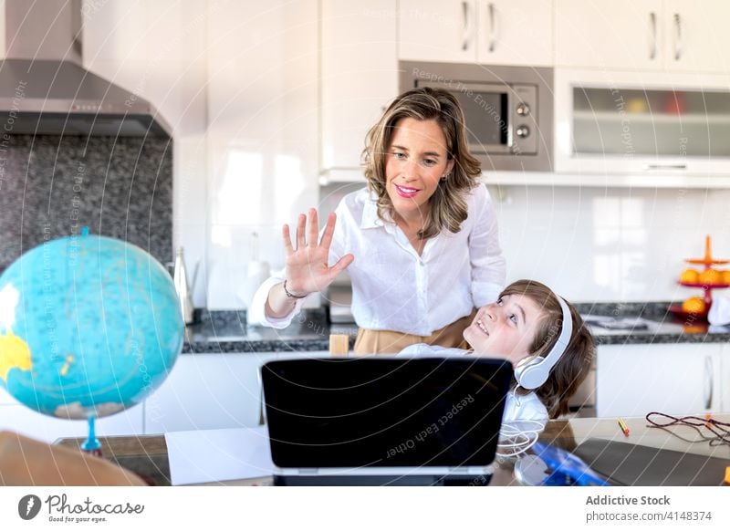 Mutter mit Sohn grüßt während eines Videogesprächs auf dem Laptop Hallo Videoanruf Gruß Umarmen Kommunizieren Kindheit benutzend Gerät Apparatur zuschauend