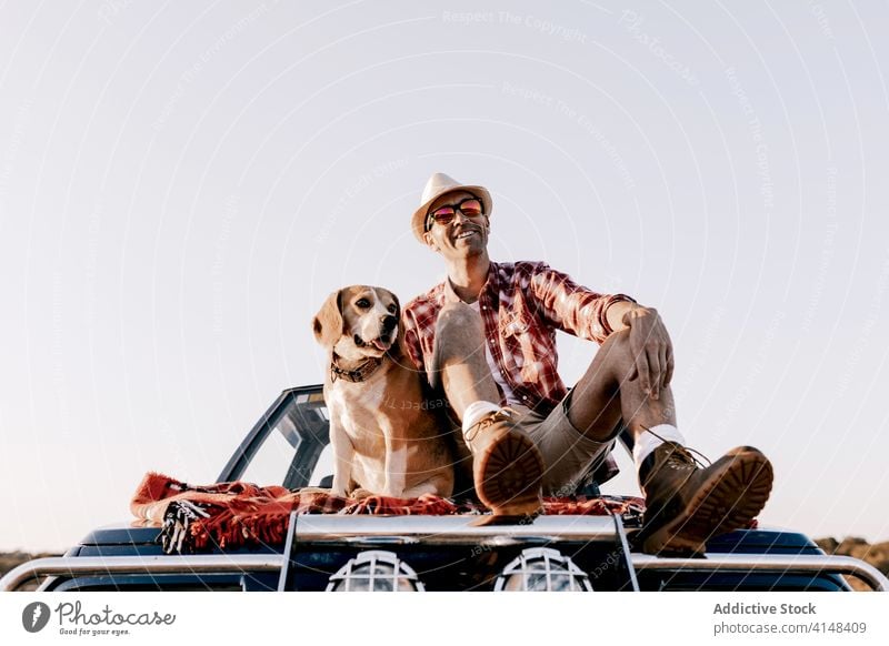 Tourist mit Hovawart genießt die Natur auf dem Auto sitzend im Sonnenlicht Hund bewundern Fluss Berge u. Gebirge PKW Urlaub Schönheit idyllisch nachdenken