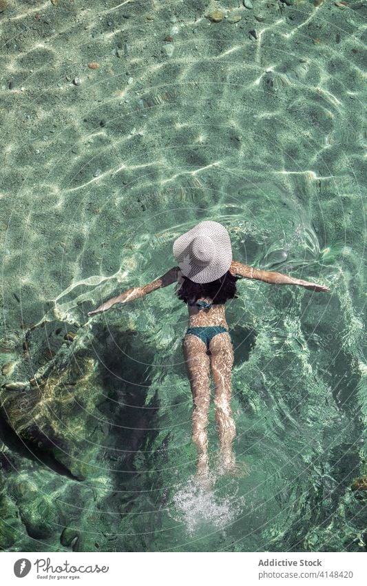 Frau schwimmt in sauberem Wasser schwimmen Resort Sauberkeit Ufer durchsichtig Sommer schlank Badebekleidung Küste ruhen idyllisch Urlaub sich[Akk] entspannen