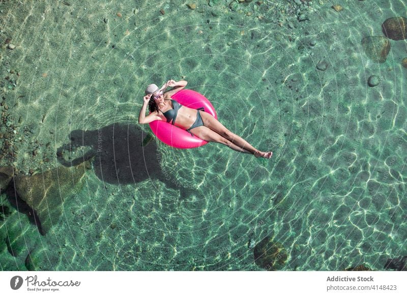 Frau schwimmt im Wasser mit Ring schwimmen Urlaub Resort Sommer Badebekleidung Sonnenbrille durchsichtig aufblasbar Tube sonnig tagsüber sich[Akk] entspannen