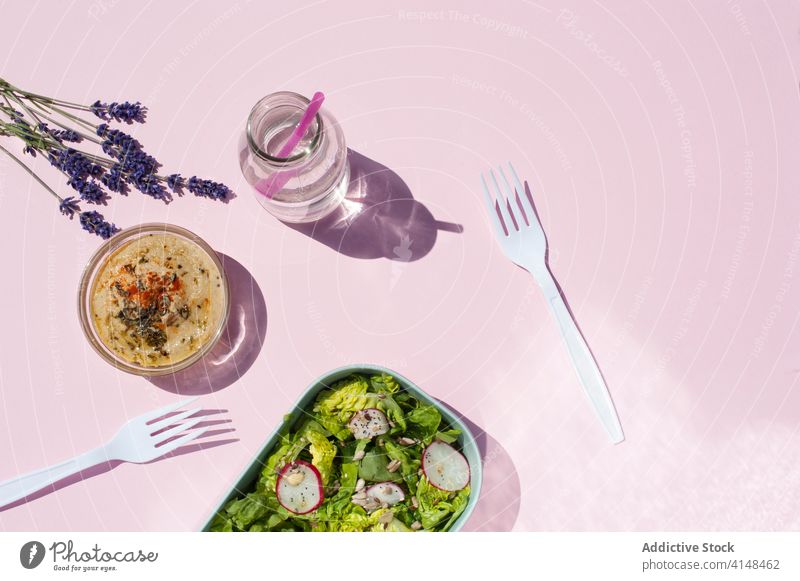 Gesundes Mittagessen auf rosa Tisch im Studio Salatbeilage Gemüse Snack Gesundheit dienen frisch Wasser natürlich gesunde Ernährung Lavendel Blume Flasche