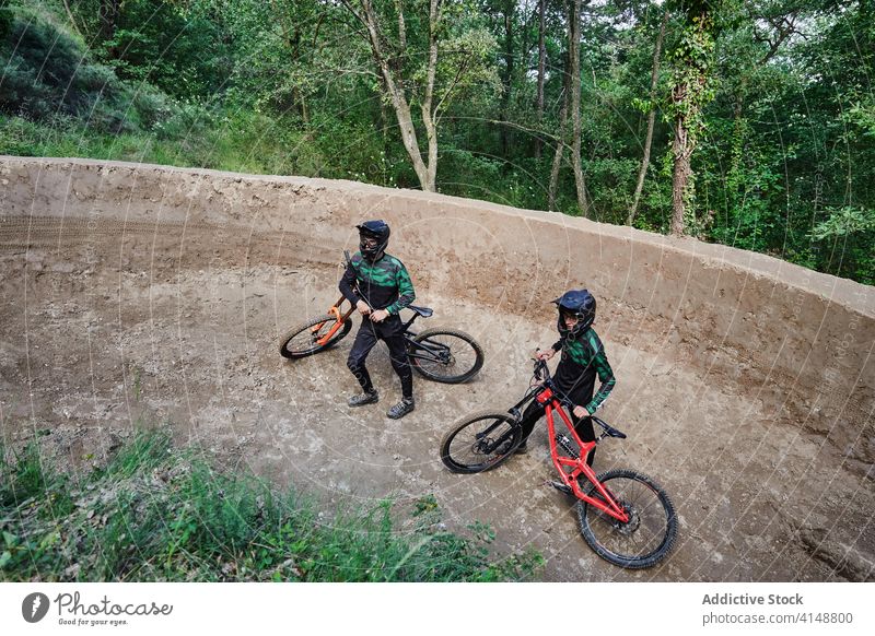Männliche Radfahrer mit Fahrrädern im Wald Männer bergab Nachlauf Weg Spaziergang Fahrrad Schutzhelm behüten Wälder Aktivität Natur sich[Akk] bewegen Sicherheit