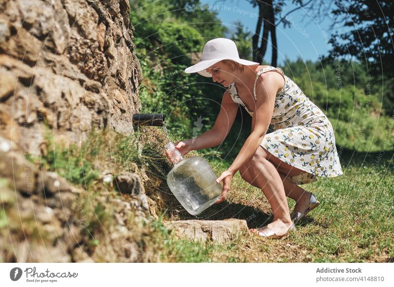 Frau mit Wasserflasche auf dem Lande natürlich Frühling aqua besetzen eingießen Flasche frisch Erfrischung Sonnenhut Kleid Kunststoff Natur Getränk Sommer