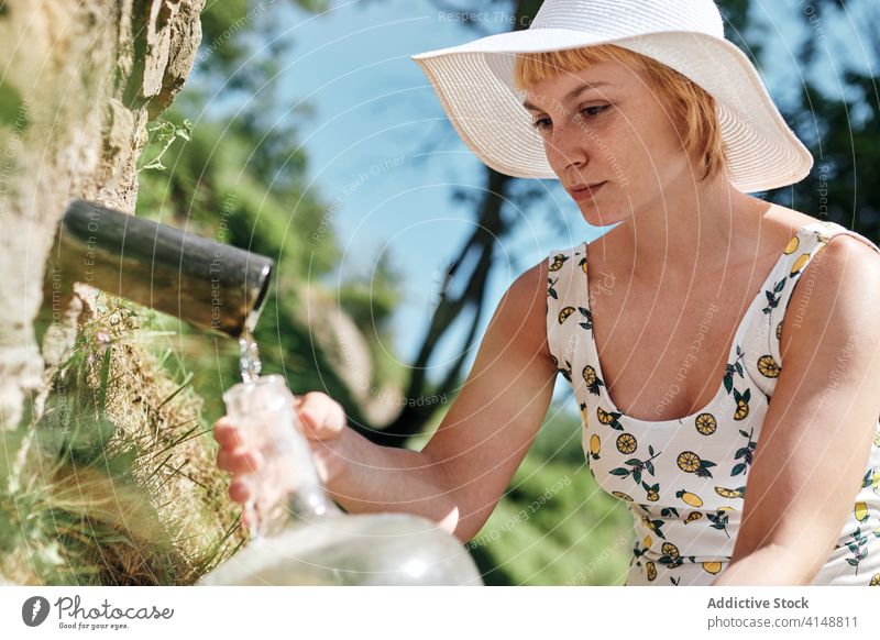 Frau mit Wasserflasche auf dem Lande natürlich Frühling aqua besetzen eingießen Flasche frisch Erfrischung Sonnenhut Kleid Kunststoff Natur Getränk Sommer