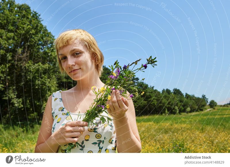 Lächelnde Frau in blühendem Feld Sommer Blumenstrauß Wiese Blüte sonnig Inhalt Kleid Glück Landschaft Blütezeit jung genießen frisch sich[Akk] entspannen