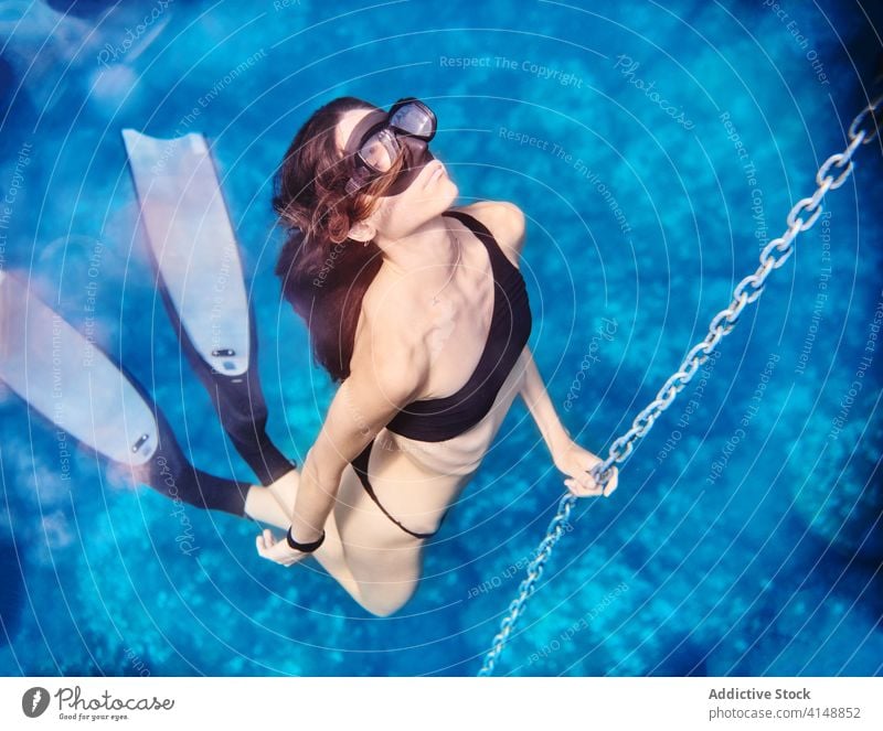 Frau schwimmt unter Wasser im blauen Meer Taucher schwimmen MEER Sinkflug unterseeisch Sauberkeit Bikini tief Schutzbrille Mundschutz Feiertag Badebekleidung