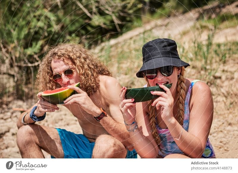 Paar isst Wassermelone an einem sonnigen Tag essen Freund Menschen Zusammensein genießen Sommer Feiertag süß lecker Wald Baum Totholz Unternehmen Menschengruppe