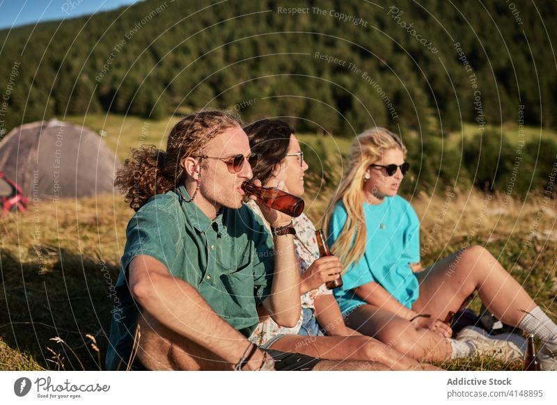 Entspannte Reisende auf einem Hügel im Sommer Reisender Unternehmen sich[Akk] entspannen trinken Bier Zusammensein Zelt Lager Campingplatz sonnig Freundschaft