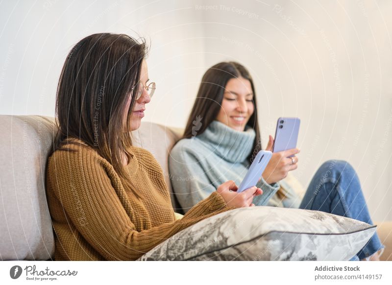 Glückliche Frauen beim gemeinsamen Surfen auf dem Handy Freundschaft soziale Netzwerke Browsen Smartphone Zusammensein bester Freund heimwärts benutzend