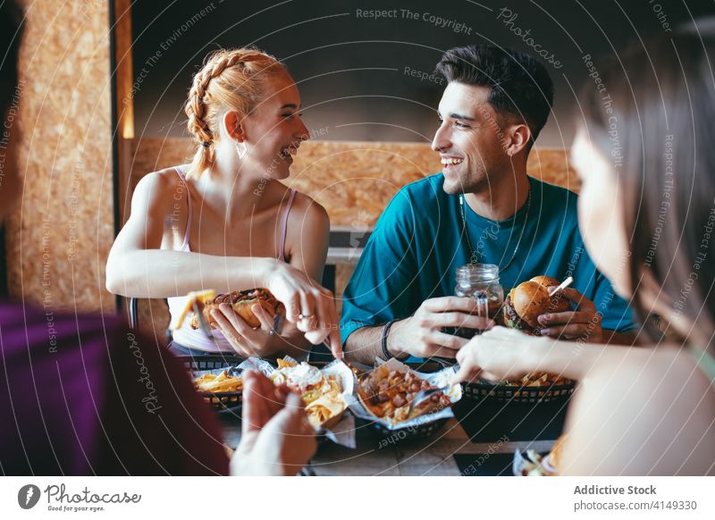 Fröhliche Freunde haben Spaß in Fast-Food-Café essen Spaß haben Fastfood heiter Glück Paar jung Zusammensein Lachen Lifestyle Freundschaft Sitzung Kommunizieren