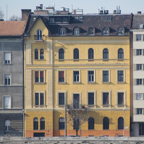 Budapester Stadthaus Fassade Architektur Uferbefestigung authentisch orange Stil Sonnenlicht Farbgestaltung Strukturen & Formen kahler Baum Häuserzeile