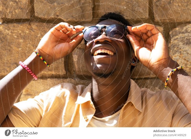 Entzückter ethnischer Mann mit Sonnenbrille Stil heiter Großstadt trendy Freude Sommer sonnig sorgenfrei männlich schwarz Afroamerikaner Barcelona Spanien