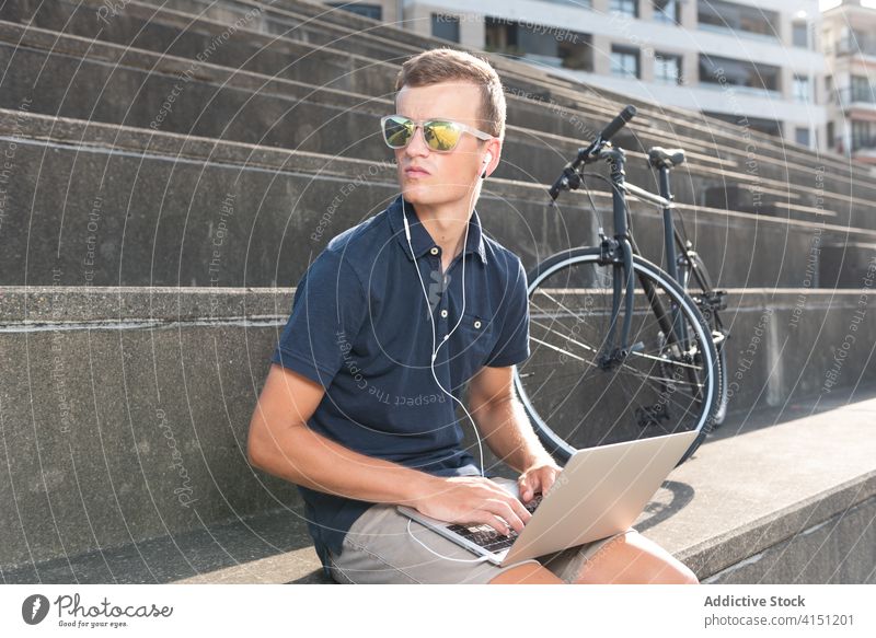 Mann arbeitet auf der Straße in der Nähe seines Fahrrads blond Business Kaukasier Mitteilung Computer Textfreiraum Fahrradfahren Radfahrer Unternehmer
