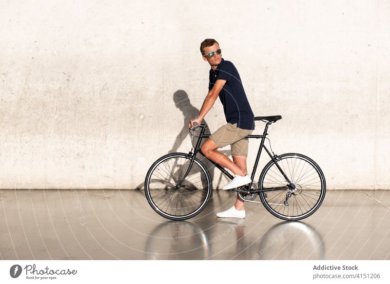 Mann mit Fahrrad an Betonwand Erwachsener blond lässig Kaukasier Textfreiraum Fahrradfahren Radfahrer Lifestyle männlich tausendjährig Mobilität modern Menschen