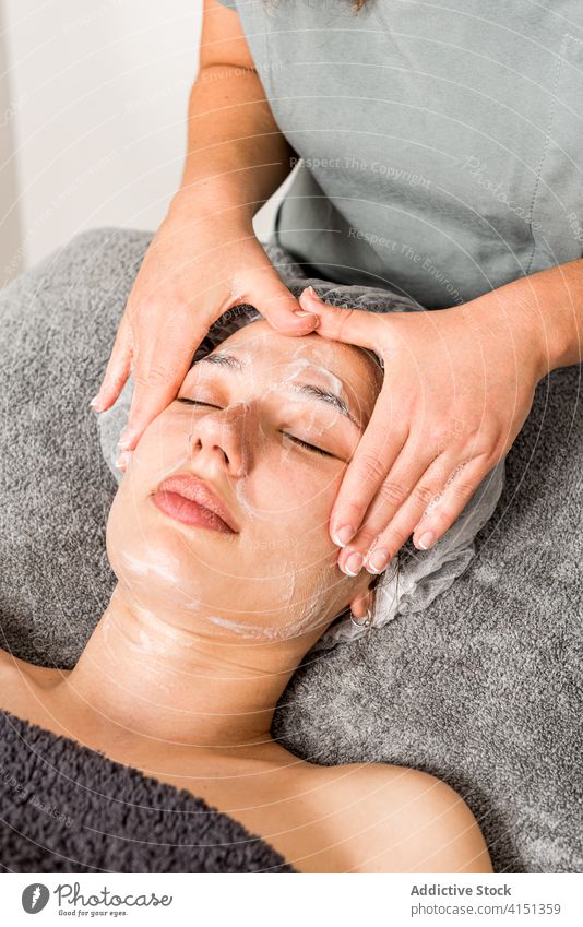 Frau bekommt Gesichtsmaske im Schönheitssalon Kosmetologie Mundschutz Kosmetikerin Leckerbissen bewerben geduldig Gesichtsbehandlung Hautpflege verwöhnen Kunde