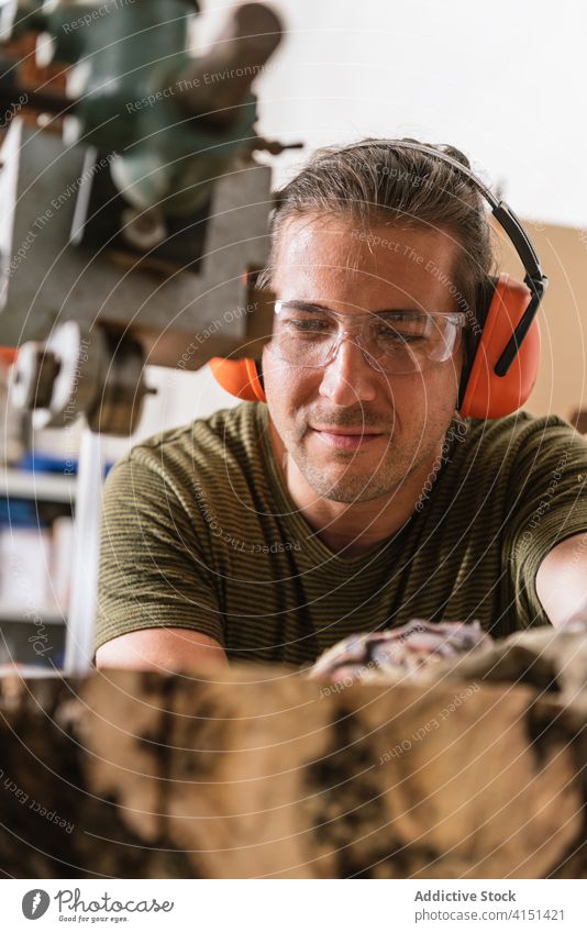 Männlicher Holzarbeiter schneidet Holz in der Werkstatt geschnitten Bandsäge Zimmerer Mann Tischlerin Holzarbeiten professionell männlich Nutzholz Säge schäbig
