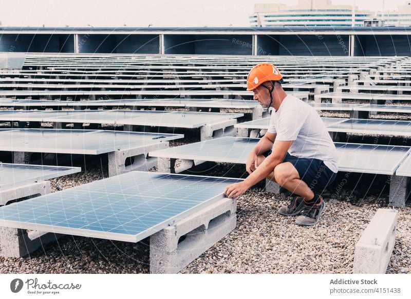Fleißiger Arbeiter in der Nähe von Solarbatterien solar Panel Batterie installieren Mann nachhaltig industriell alternativ Kraft männlich Ingenieur Entwicklung