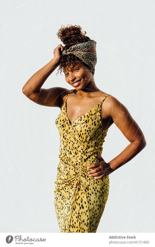 Charmante Frau auf der Straße an einem sonnigen Tag Stirnband trendy Stil Sommer Bekleidung charmant Lächeln Großstadt Mode ethnisch schwarz Afroamerikaner