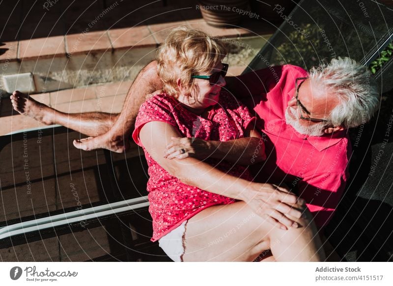 Verliebtes älteres Paar entspannt sich auf der Terrasse Sommer Resort Zusammensein Lügen Liegestuhl Sonnenbad Umarmung Urlaub sich[Akk] entspannen Angebot