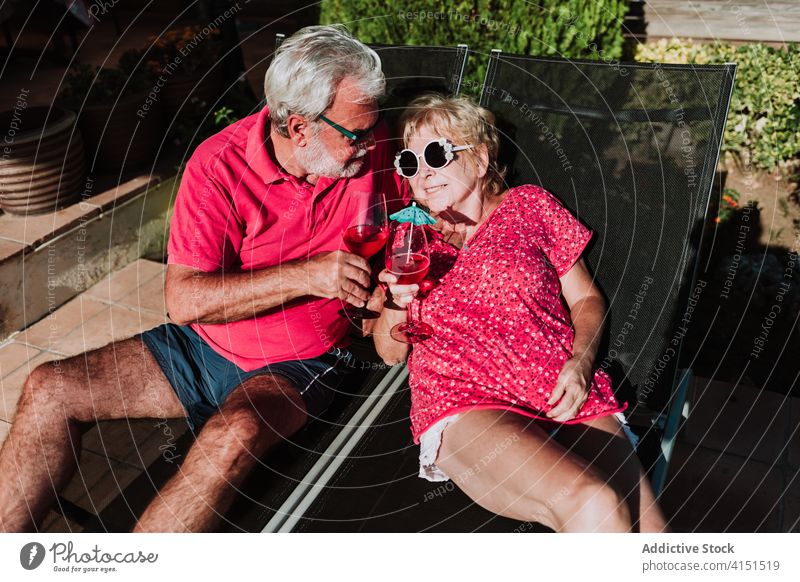 Zufriedenes älteres Paar auf Liegestühlen Sommer Urlaub Cocktail tropisch Senior sich[Akk] entspannen Zusammensein Liegestuhl Lügen Terrasse Getränk Kälte