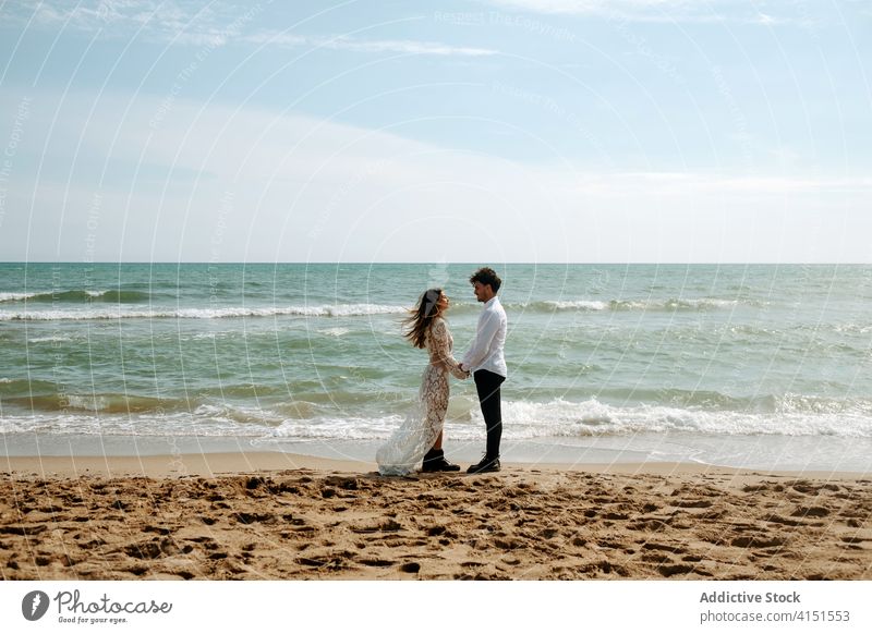 Verliebtes Paar in der Nähe der Meereswellen romantisch Jungvermählter Strand MEER Zusammensein Partnerschaft Liebe sanft winken Angebot genießen Seeküste Natur