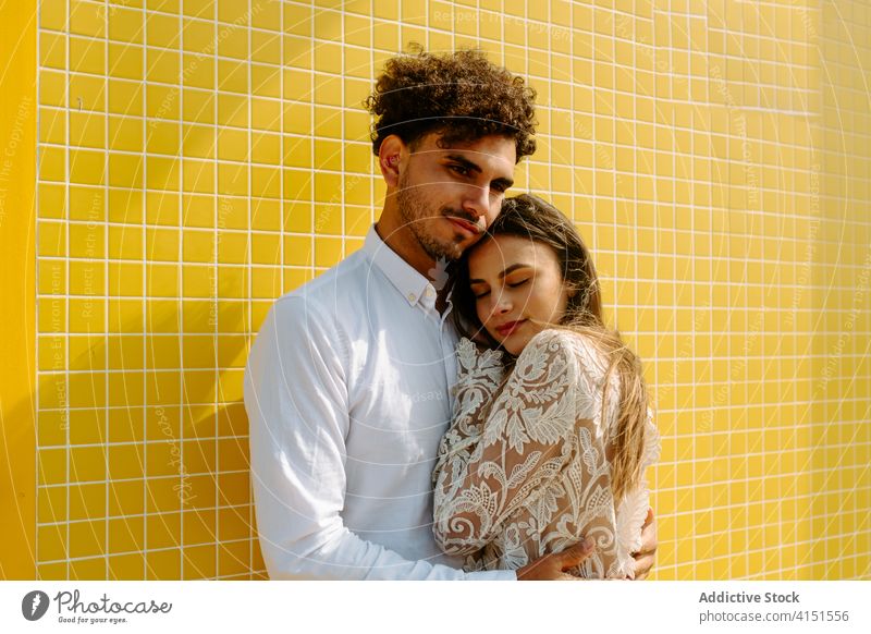 Stilvolles romantisches Paar, das sich in der Nähe der Wand umarmt Liebe Umarmen Angebot Pflege Jungvermählter Zusammensein Partnerschaft sanft Harmonie amourös