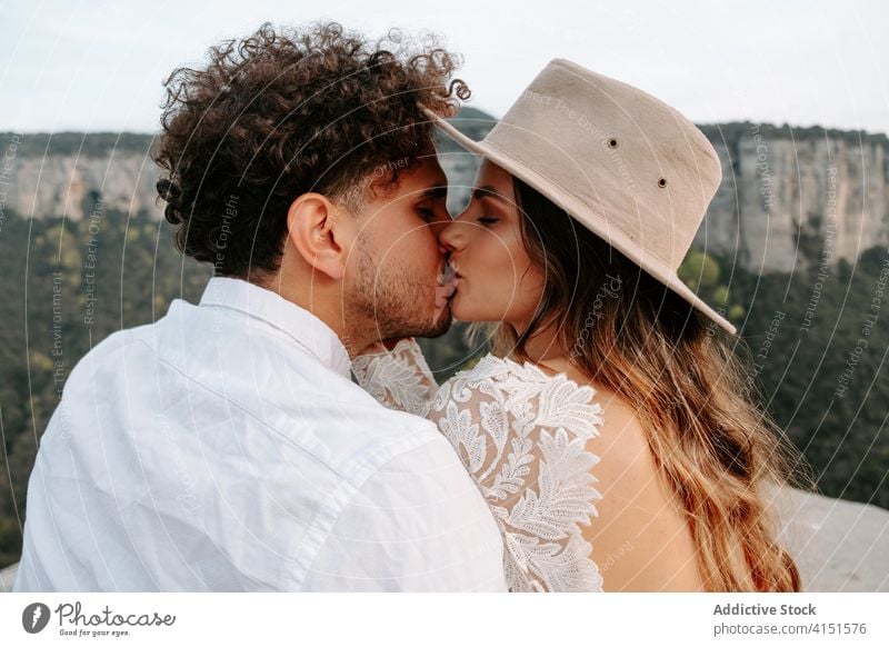 Zärtliches frisch verheiratetes Paar küsst sich in den Bergen romantisch Jungvermählter Liebe jung Berge u. Gebirge Felsen Kuss Glück Natur Zusammensein