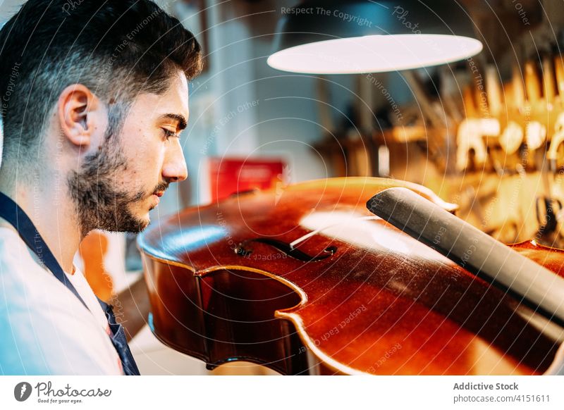 Kunsthandwerker bei der Prüfung eines Musikinstruments in der Werkstatt Zupfinstrumentenmacher Reparatur Instrument Kunstgewerbler machen prüfen