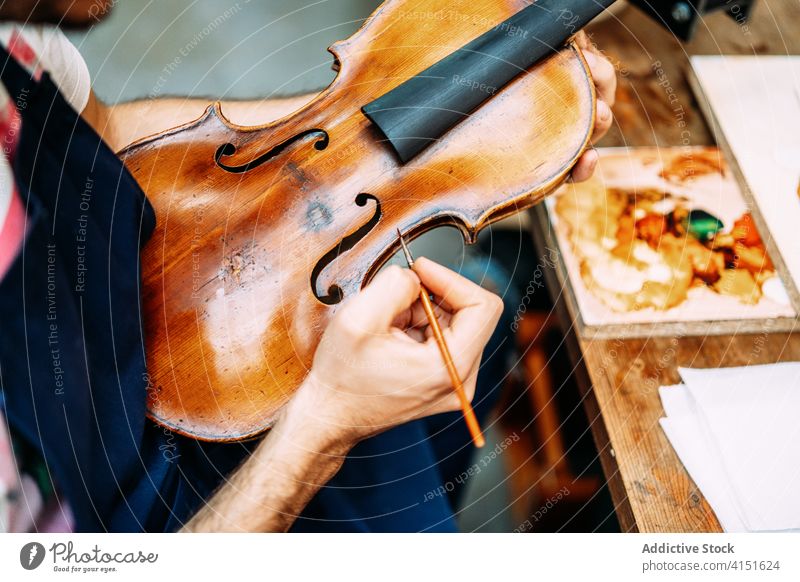 Anonymer Geigenbauer restauriert alte Geige in seiner Werkstatt wiederherstellen Farbe Instrument Reparatur Kunstgewerbler machen Mann Handwerk Werkzeug