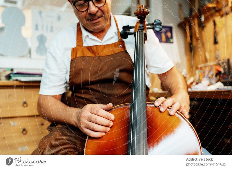 Geschickter Geigenbauer, der mit Streichinstrumenten arbeitet Zupfinstrumentenmacher Arbeit Instrument Reparatur Kunstgewerbler machen prüfen wiederherstellen