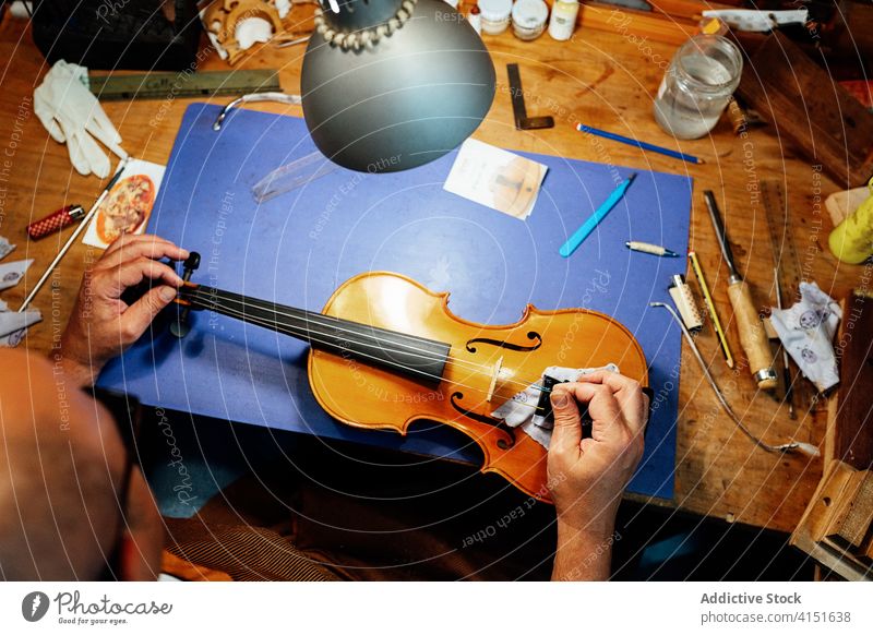 Anonymer Handwerker beim Zusammenbau des Stegs einer Geige Reparatur Brücke Schnur Zupfinstrumentenmacher Kunsthandwerker Kunstgewerbler wiederherstellen Arbeit