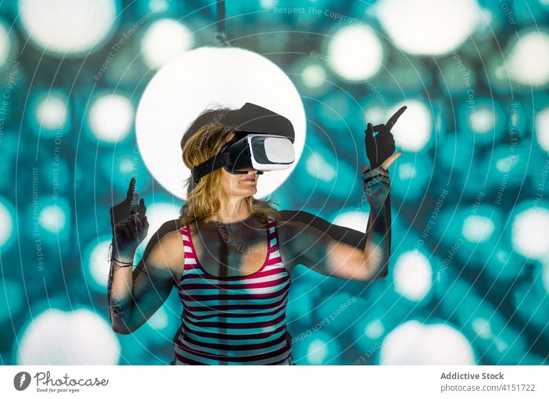 Frau in VR-Brille erkundet virtuelle Realität Virtuelle Realität Headset Schutzbrille berühren Erfahrung erkunden leuchten Projektor Technik & Technologie