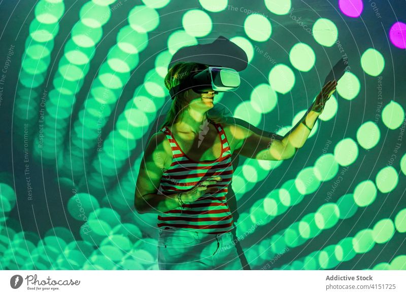 Frau in VR-Brille erkundet virtuelle Realität Virtuelle Realität Headset Schutzbrille berühren Erfahrung erkunden leuchten Projektor Technik & Technologie