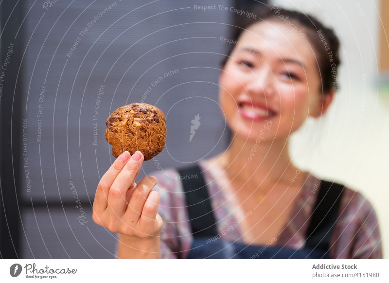 Zufriedene Frau demonstriert Haferflockenkeks Keks Bäcker Glück lecker heimwärts Küche Dessert Müsli Korn zufrieden Konditorei Gebäck geschmackvoll zeigen