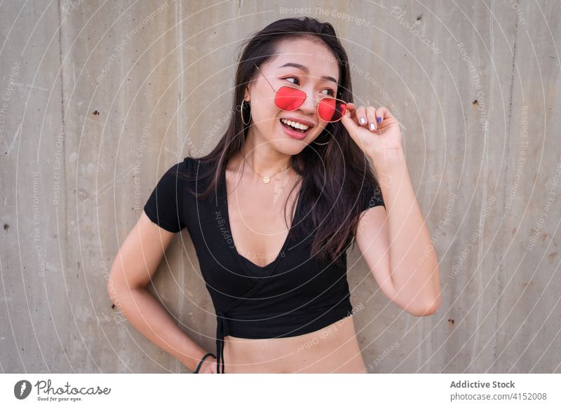 Frau in trendiger Kleidung in der Stadt Stil urban Outfit Lächeln Freude lässig trendy Mode Großstadt ethnisch asiatisch Sonnenbrille Sommer