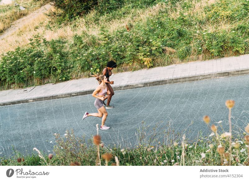 Glückliche sportliche Frauen beim Laufen auf der Straße Training laufen Fitness aktiv bergauf joggen Übung Zusammensein urban Hügel anstrengen Läufer Optimist