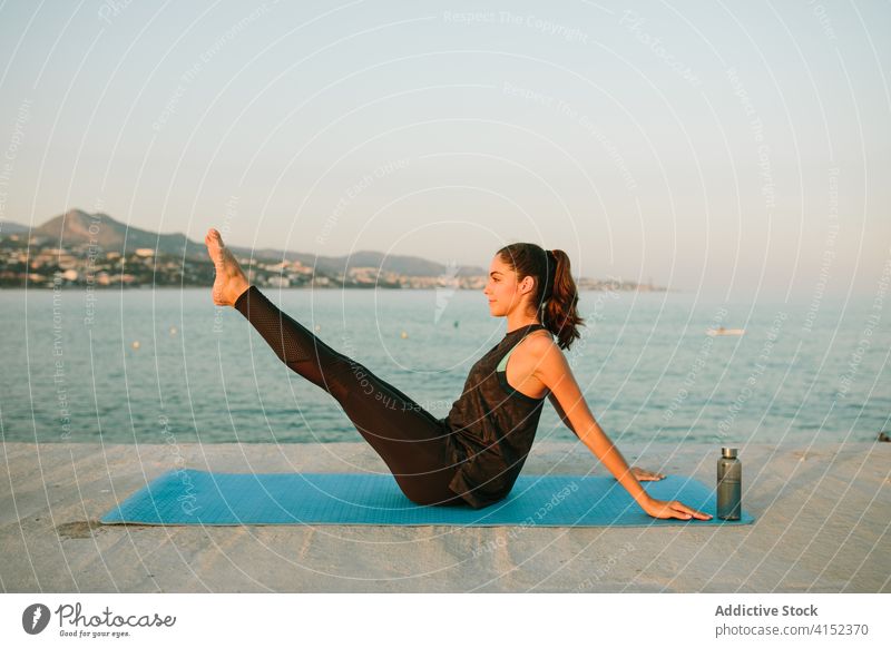 Frau übt Yoga in Boots-Asana Boot-Pose navasana MEER Pier üben Unterlage Sonnenuntergang friedlich sich[Akk] entspannen Gesundheit Sportbekleidung