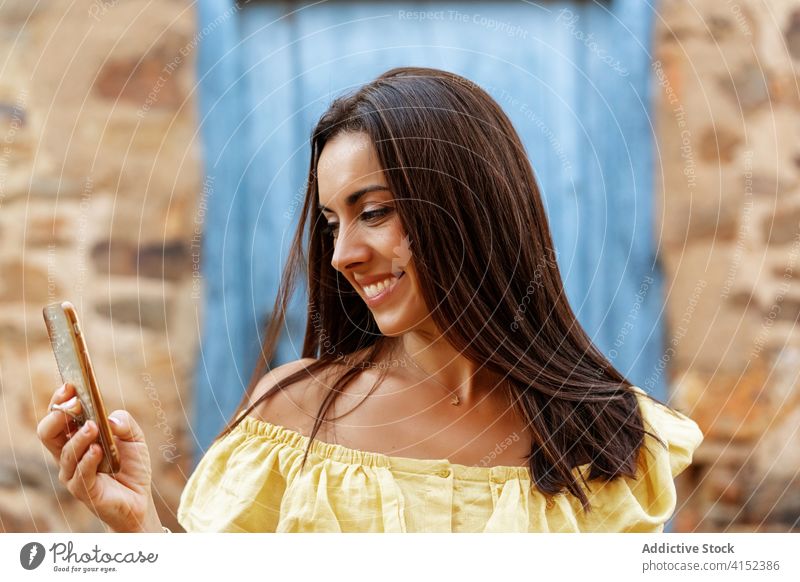 Lächelnde Frau beim Surfen auf dem Handy in der Stadt lesen Nachricht Smartphone Sommer Wochenende benutzend alt soziale Netzwerke Inhalt Internet online ruhen