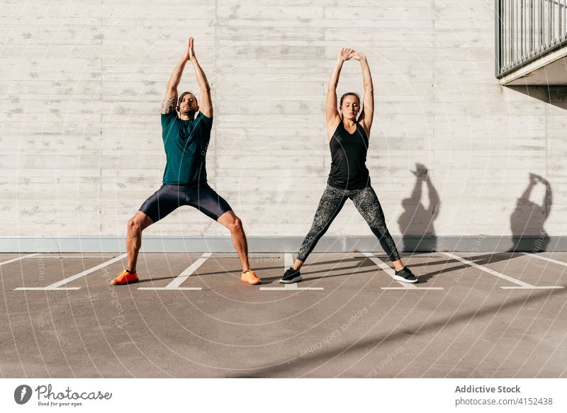Sportliches Paar beim Aufwärmen vor dem Training Dehnung Körper Zusammensein Athlet beweglich Sportbekleidung Gesundheit Aktivität Wohlbefinden stehen