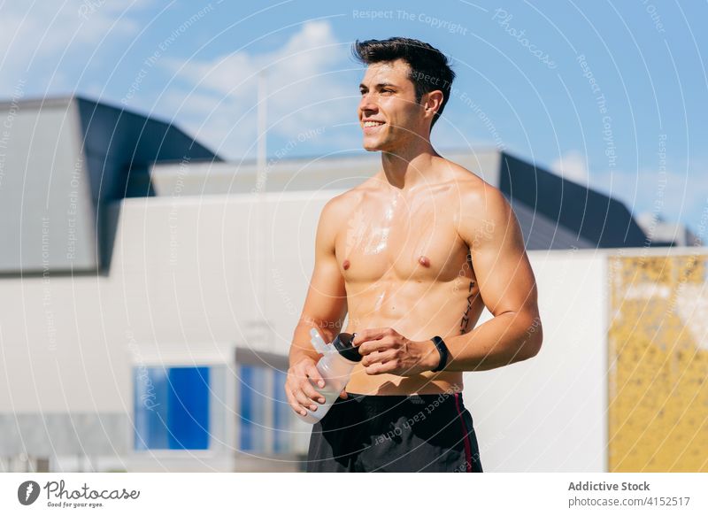 Verschwitzter Sportler mit Wasserflasche beim Training Lächeln Mann Schweiß Erfrischung müde Glück sonnig ruhen männlich Athlet Terrasse Flasche trinken