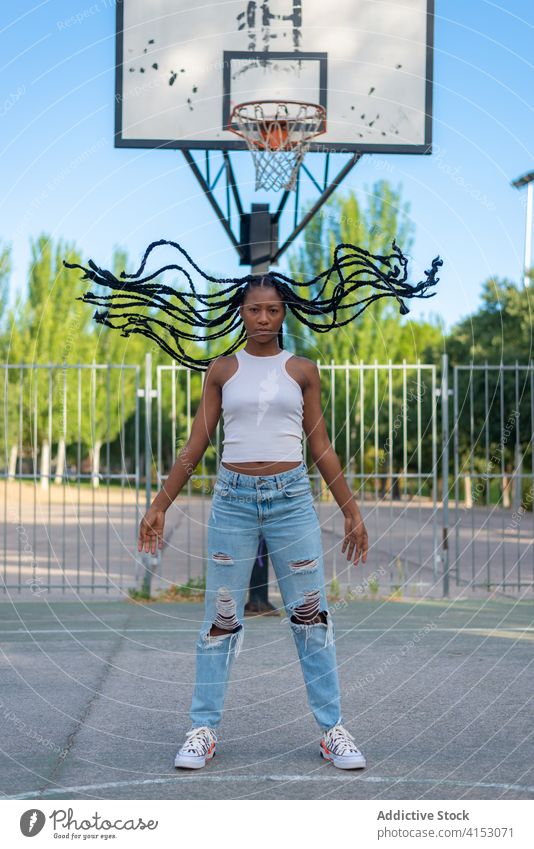 Trendige junge schwarze Frau mit Afro-Zöpfen Geflecht Afro-Look urban Stil trendy Hipster Behaarung Zopf Sportpark Park Afroamerikaner Streetstyle ethnisch