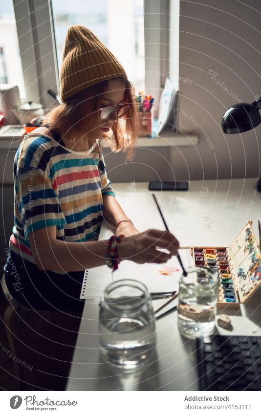 Kreative Frau malt im Workshop Wasserfarbe Malerei Werkstatt Künstler kreativ Kunst Farbe Pinselblume Talent Anstreicher Tisch Arbeit Konzentration