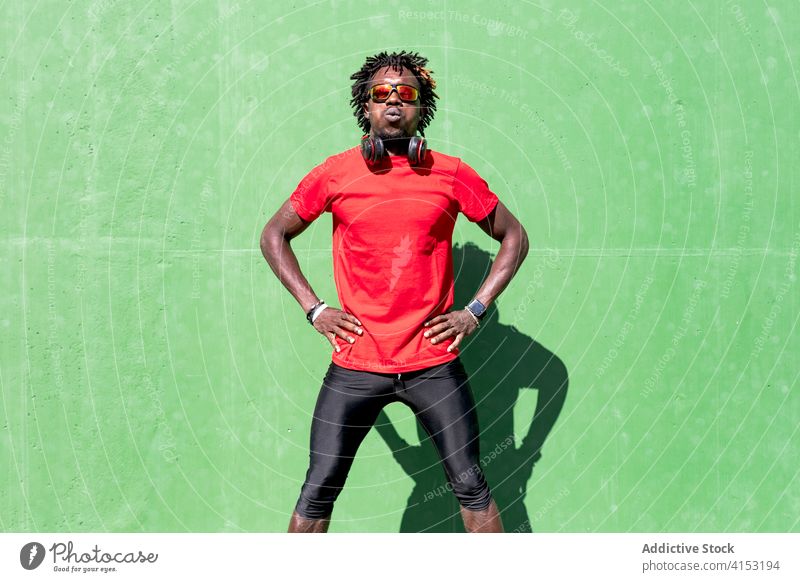Schwarzer männlicher Sportler auf der Straße müde ausatmen Pause Athlet Training sonnig stark ethnisch Afroamerikaner schwarz ruhen Sportbekleidung Fitness